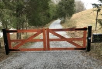 Classic wooden farm gate across gravel drive
