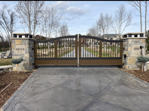 Arched wooden estate gate with stone columns and address plaque