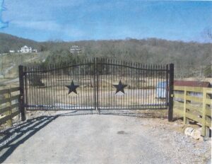 A gate with two stars on it and a fence behind it.
