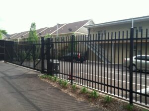 A gated driveway with a car parked in the background.