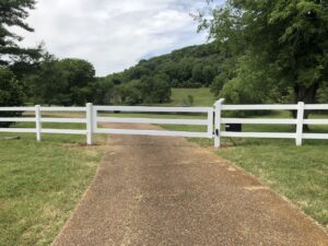 A dirt road with a gate in the middle of it